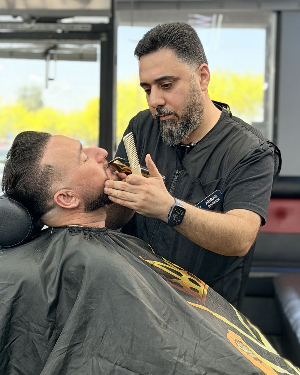 A barber lining up a client's beard